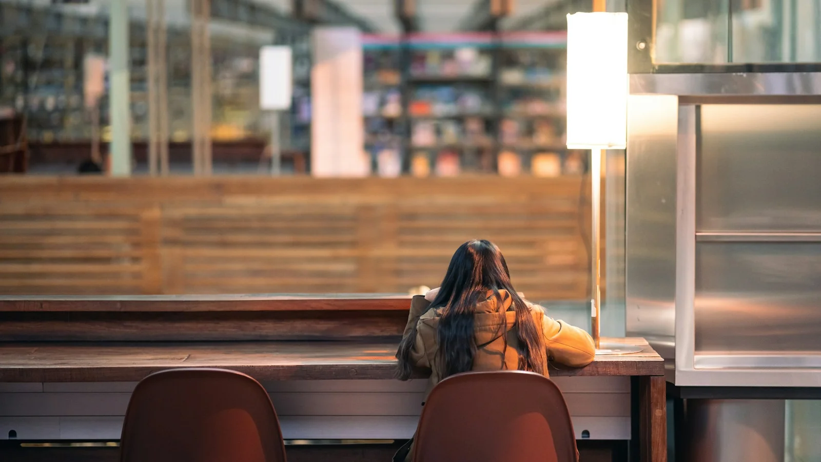 A focused student studying late in the evening, sitting on a bench outside a building