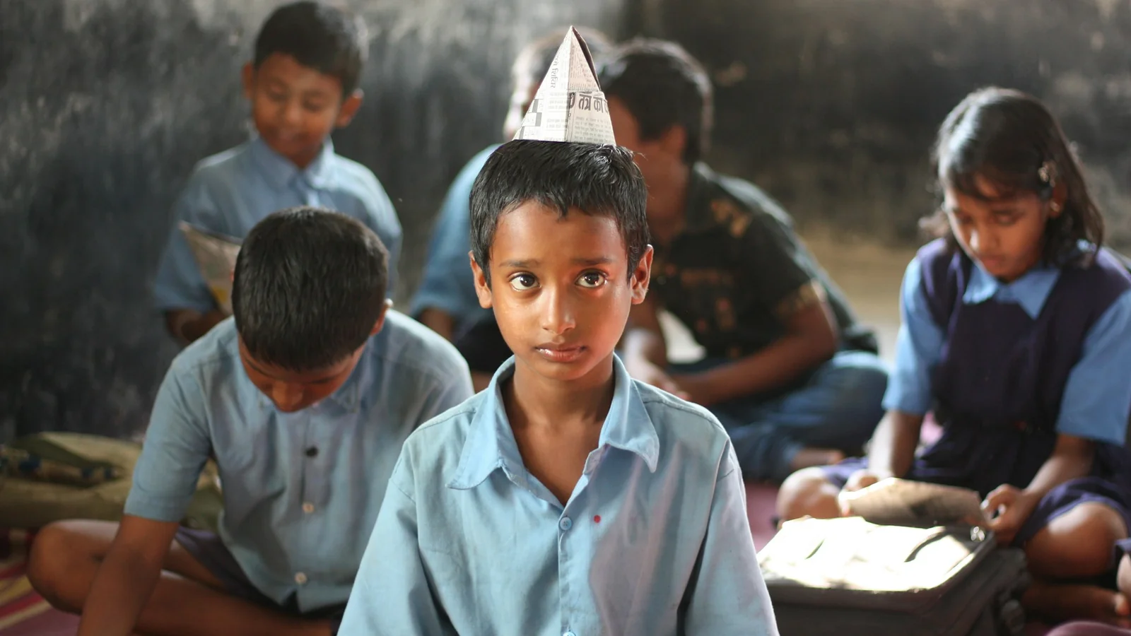 A young Indian boy in a blue dress shirt