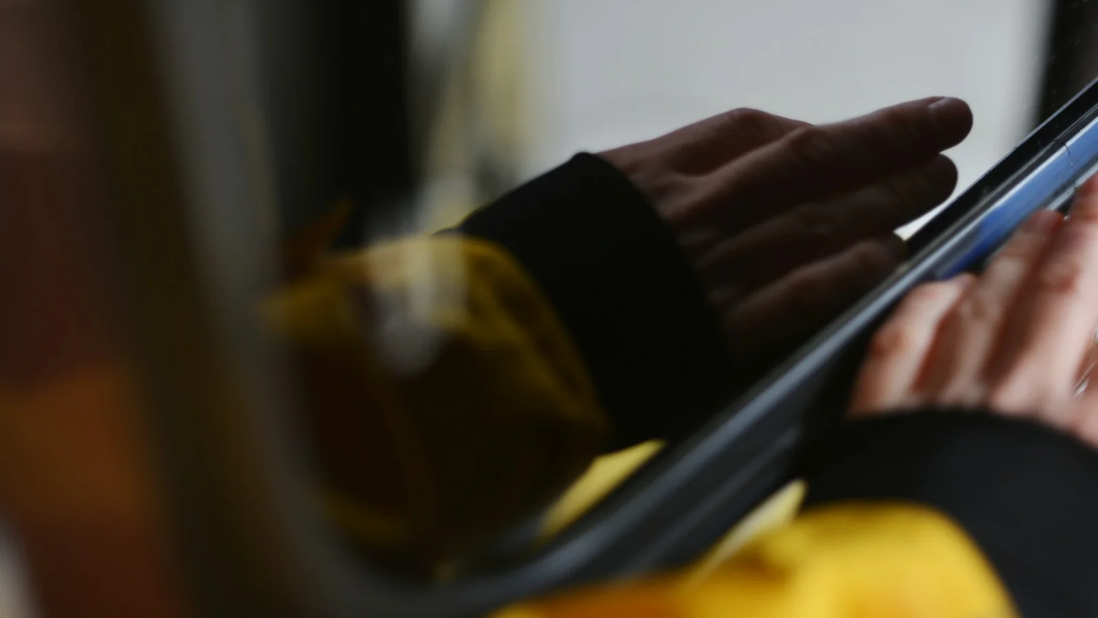 A pair of hands using a tablet device indoors