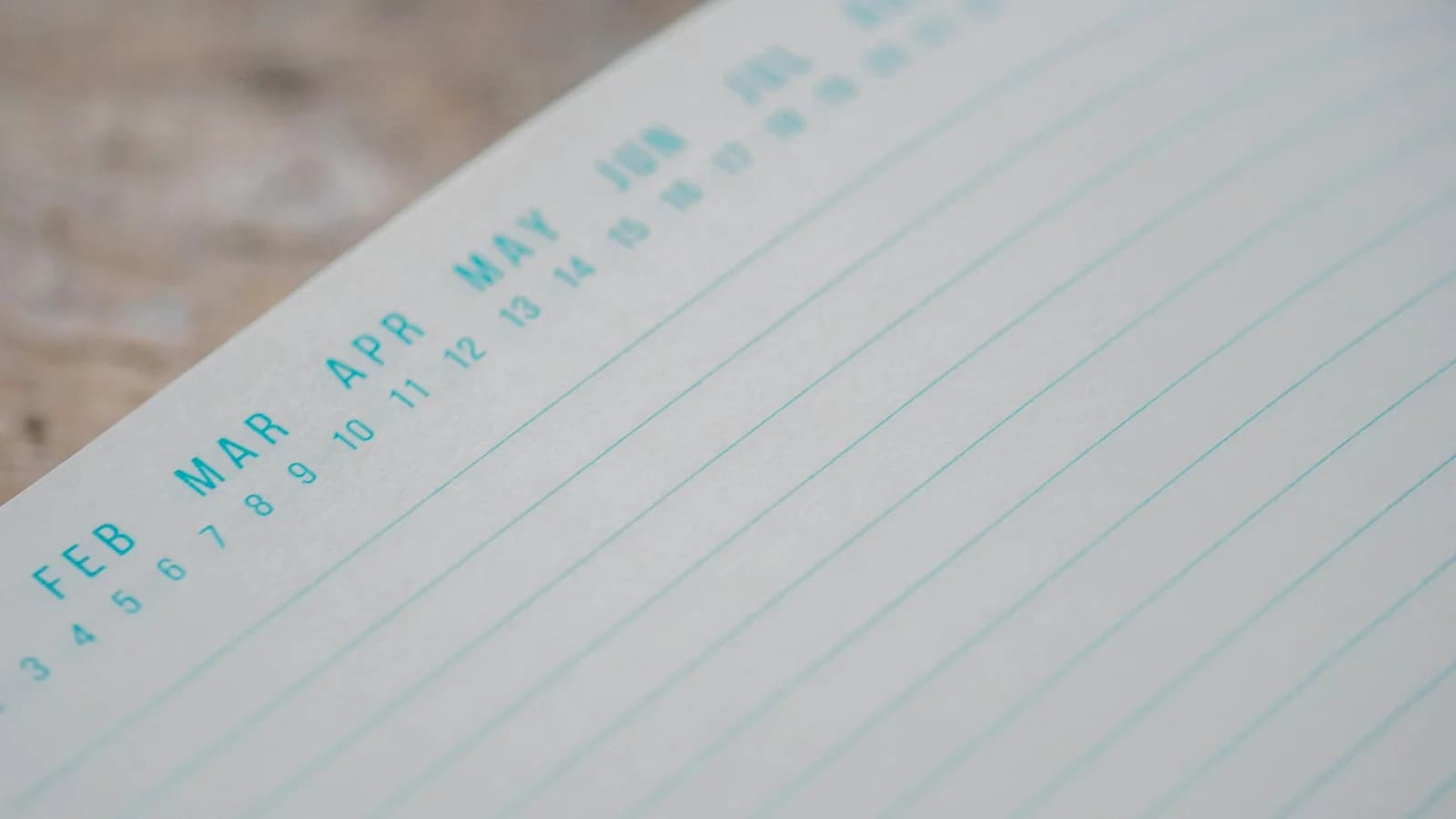 An opened planner with dates and notes on a wooden surface