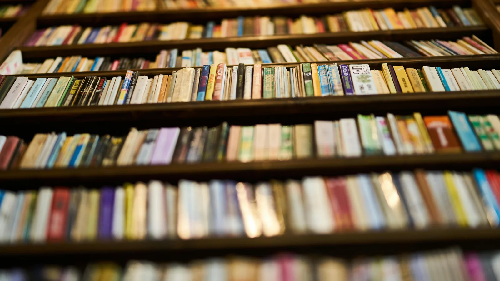 A close-up of old book spines on library shelves