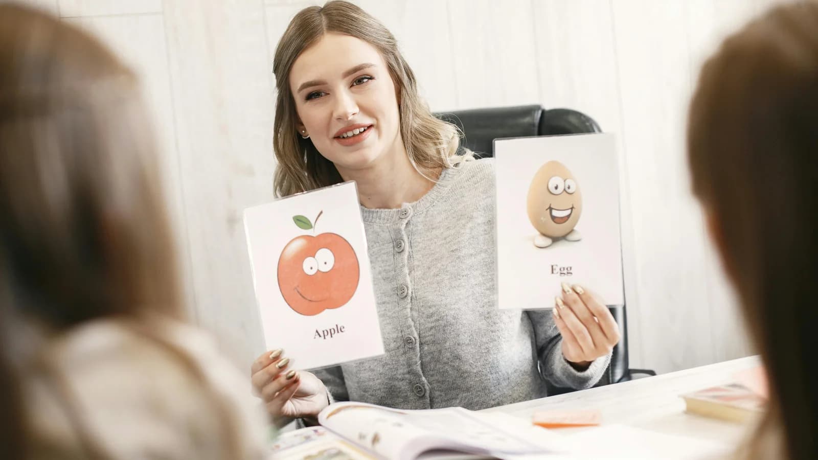 A woman holding paper flashcards while studying