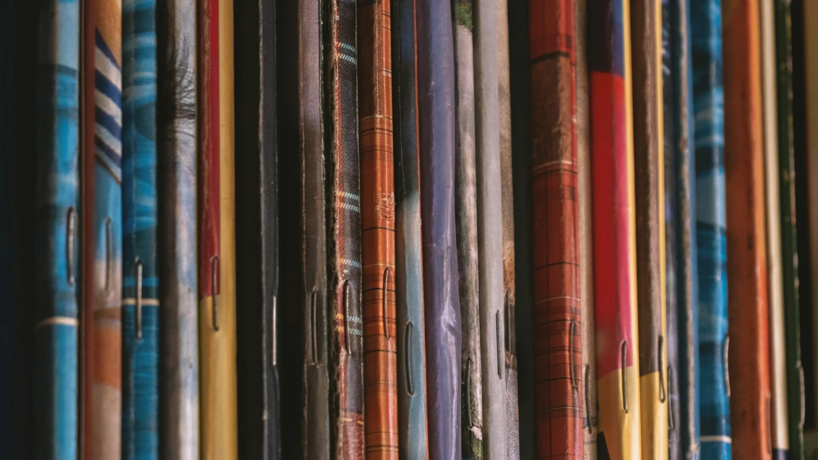 A close-up of stacked colourful magazines and newspapers